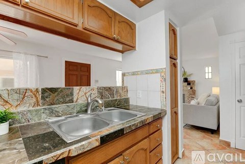 A kitchen with a marble countertop and wooden cabinets.