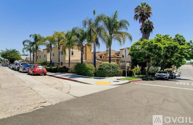 A street view with a red car parked on the side.