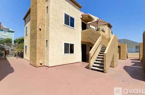 A beige building with a staircase leading to the second floor.