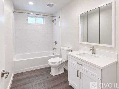 A white bathroom with a toilet, sink, and bathtub.