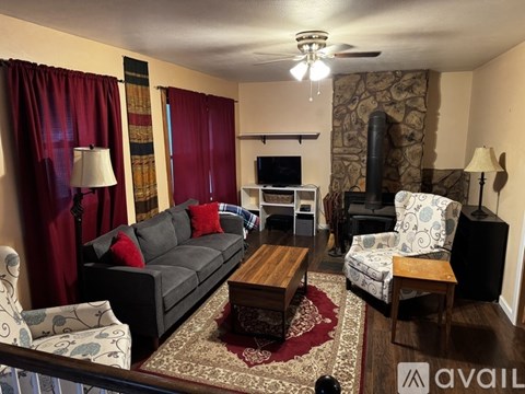A living room with a couch, chair, and fireplace.