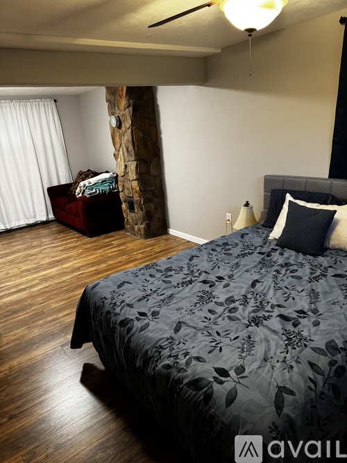 A bedroom with a large bed and a wooden floor.