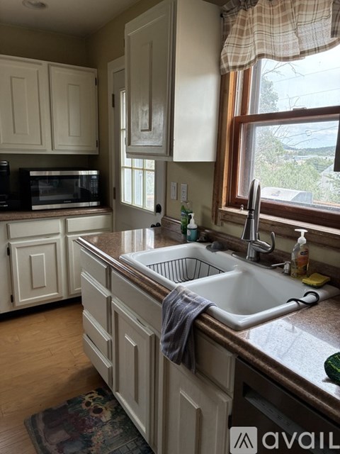 A kitchen with a white sink and cabinets.