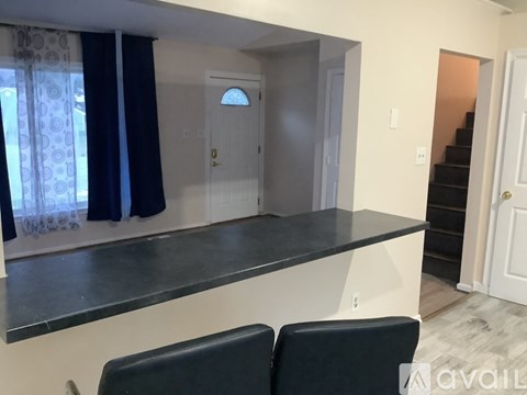 A room with a counter and two chairs.