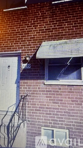 A brick building with a white door and a window.