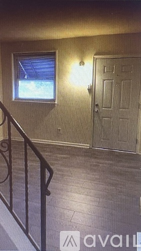 A room with a door, a window, and a railing.