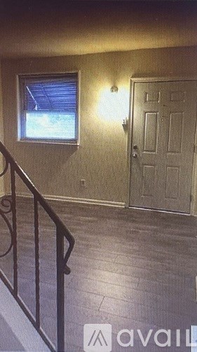 A room with a door, a window, and a railing.