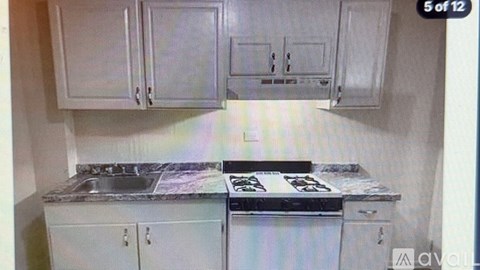 A kitchen with white cabinets and a granite countertop.