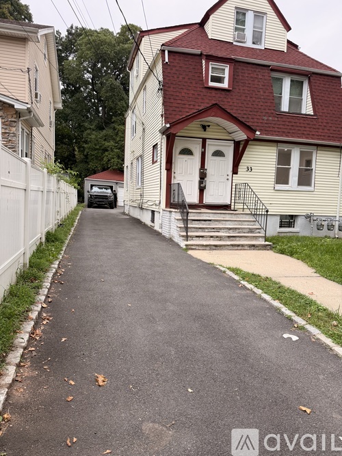 A residential street with houses on both sides and a car parked on the side.