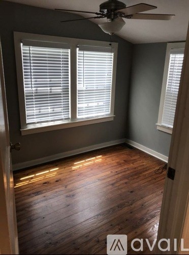 A room with wooden floors and a ceiling fan.