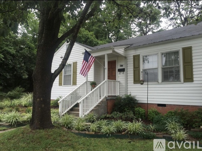 A house with a flag on the front porch is for sale.