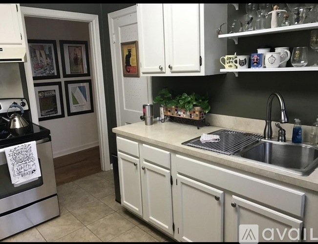A kitchen with white cabinets and a black stove top.