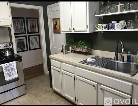 A kitchen with white cabinets and a black stove top.