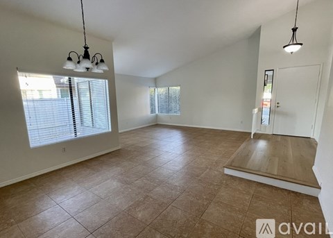 A spacious room with tiled flooring and a skylight.
