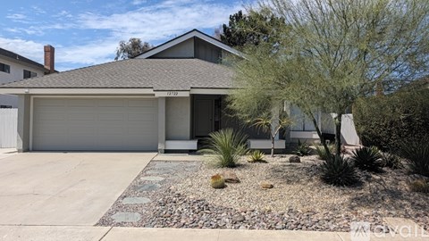 A house with a garage and a driveway in front.