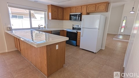 A kitchen with a white refrigerator and wooden cabinets.