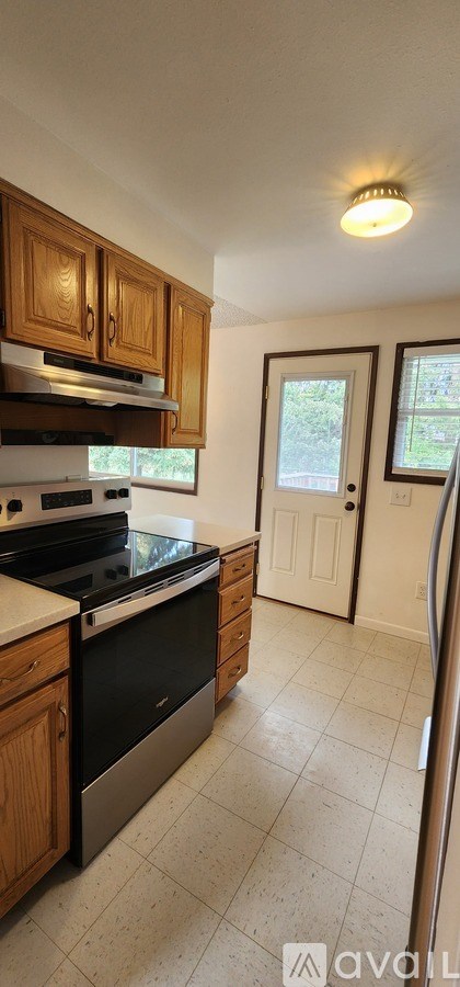 A kitchen with wooden cabinets and a black stove top oven.