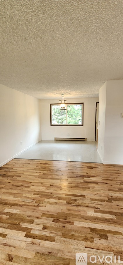 A room with wooden flooring and a window.