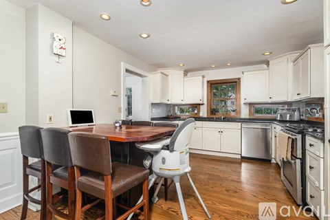 A kitchen with a table and chairs in front of it.