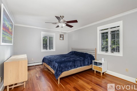 A bedroom with a bed, nightstand, and a ceiling fan.