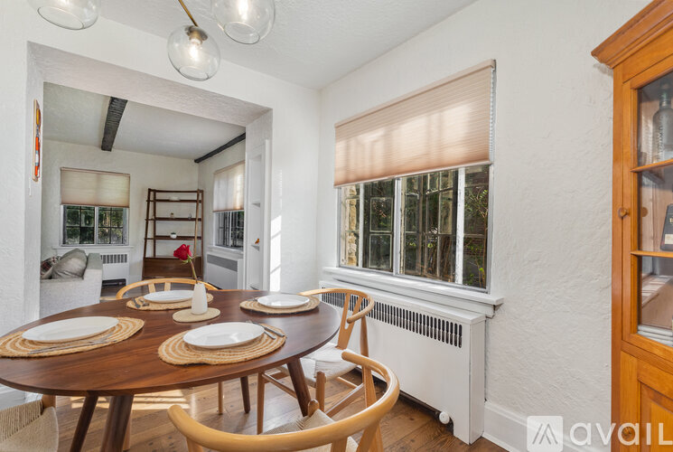 A dining room with a wooden table set for four.