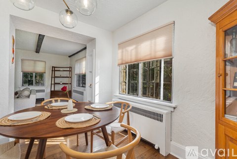 A dining room with a wooden table set for four.
