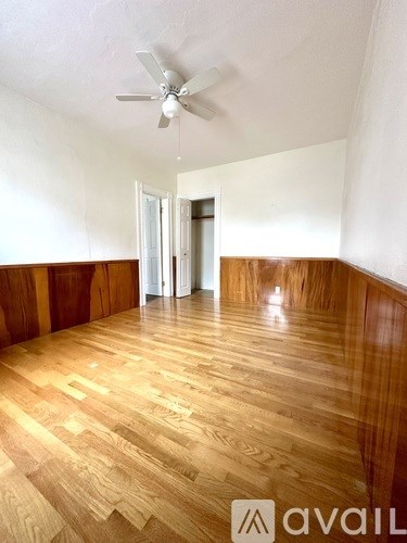 A room with wooden flooring and a ceiling fan.