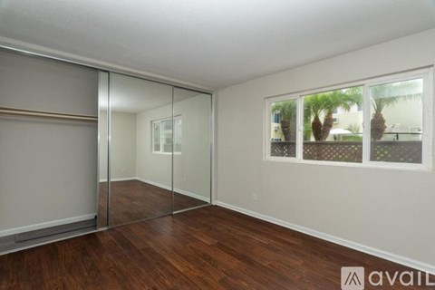 A room with wooden floors and a large mirrored wall.