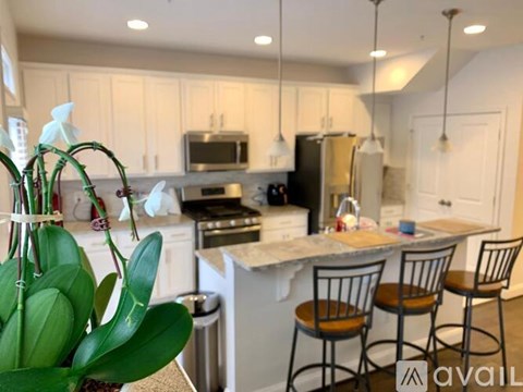 A kitchen with a white countertop and a black refrigerator.