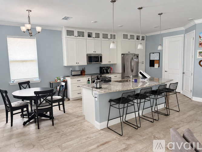 A kitchen with a table and chairs.