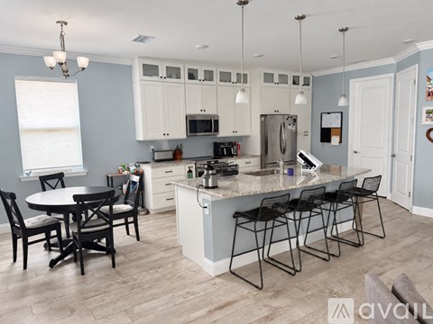 A kitchen with a table and chairs.