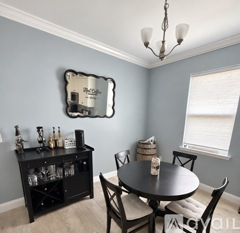 A dining room with a round table and chairs.