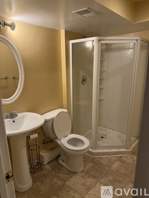 A bathroom with a toilet, sink, and shower.