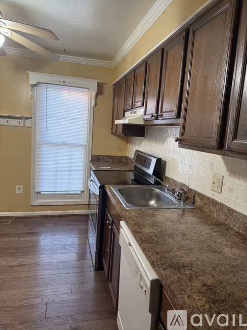 A kitchen with wooden cabinets and a stainless steel sink.