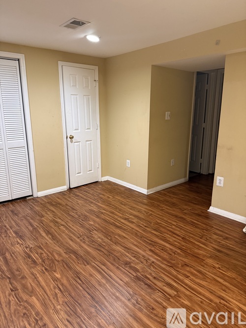 A room with wooden flooring and a white door.