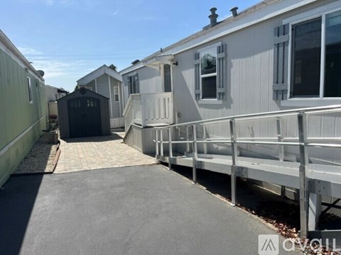 A row of mobile homes with a concrete walkway in the foreground.