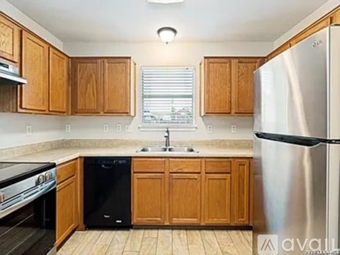 A kitchen with wooden cabinets and a stainless steel refrigerator.