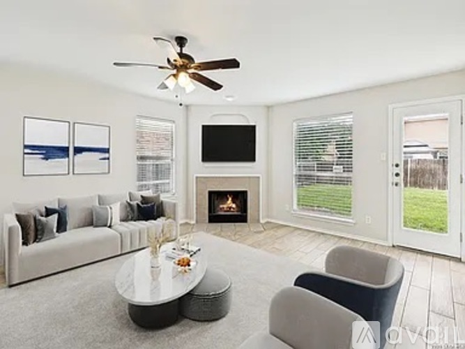A living room with a fireplace, a couch, a coffee table, and a television.