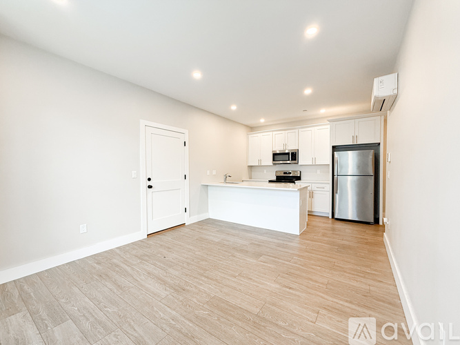 A kitchen with white cabinets and a refrigerator.