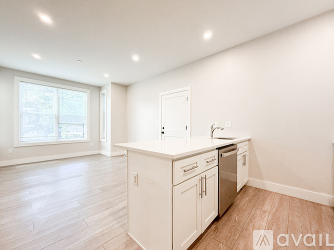 A kitchen with white cabinets and a window.