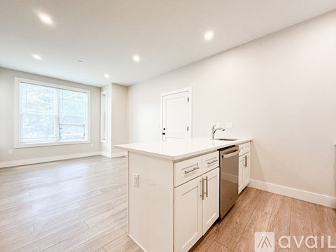 A kitchen with white cabinets and a window.