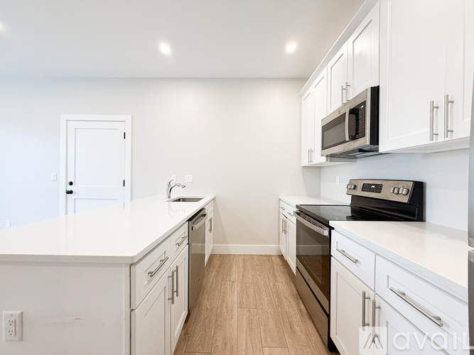 A kitchen with white cabinets and appliances.