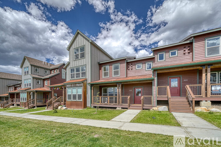 A row of houses with a blue sky and clouds in the background.
