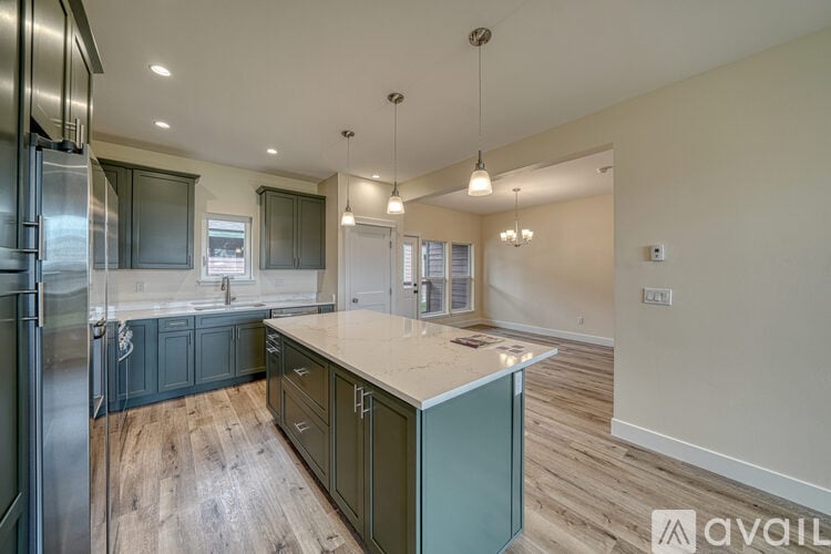 A kitchen with wooden floors and a large island.