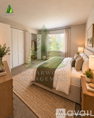 A bedroom with a bed, nightstand, and a window with a view of trees.