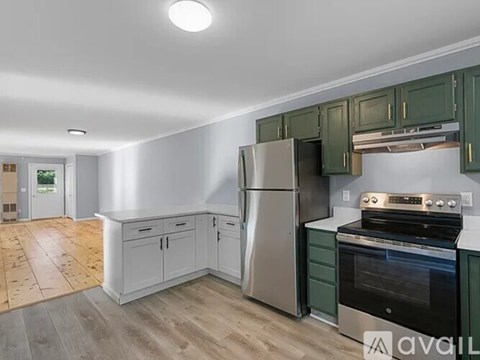 A kitchen with a refrigerator, oven, and cabinets.