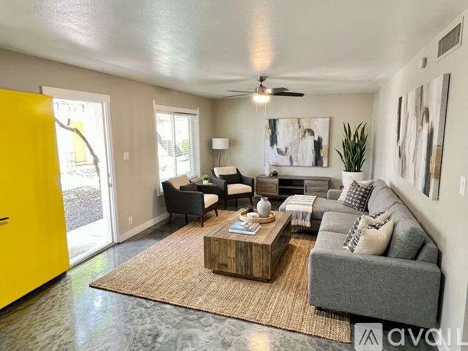 A living room with a grey couch, a yellow door, and a coffee table.