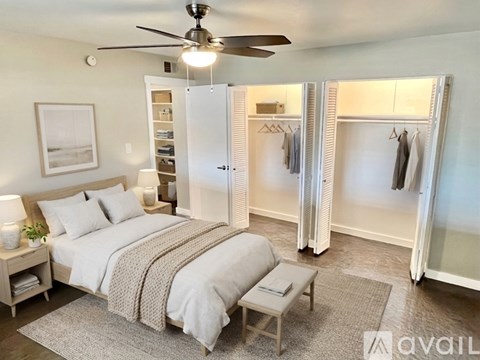 A bedroom with a large bed and a ceiling fan.
