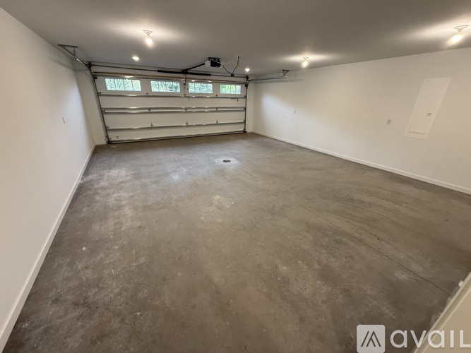 A spacious garage with a concrete floor and a window with blinds.