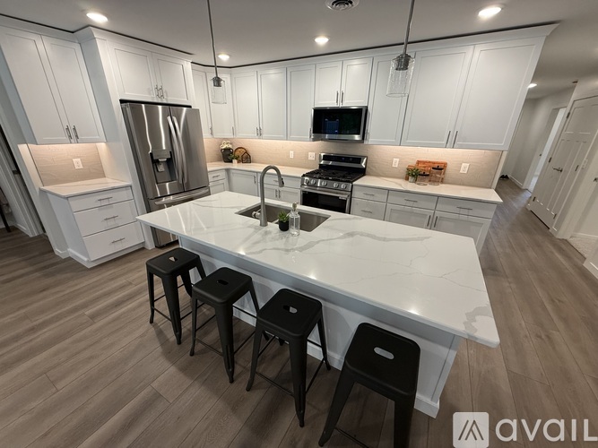 A modern kitchen with white cabinets and a central island.
